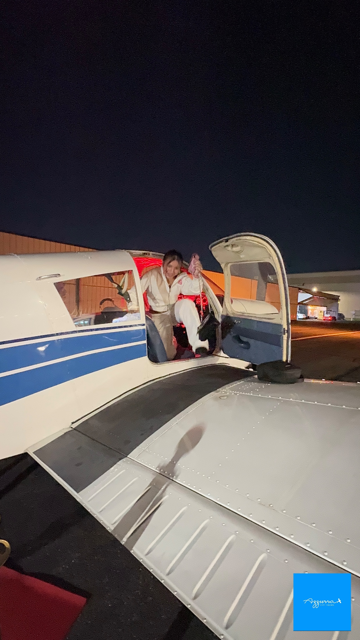 Valerie C. with her hands on the controls of the Piper Cherokee alongside her pilot